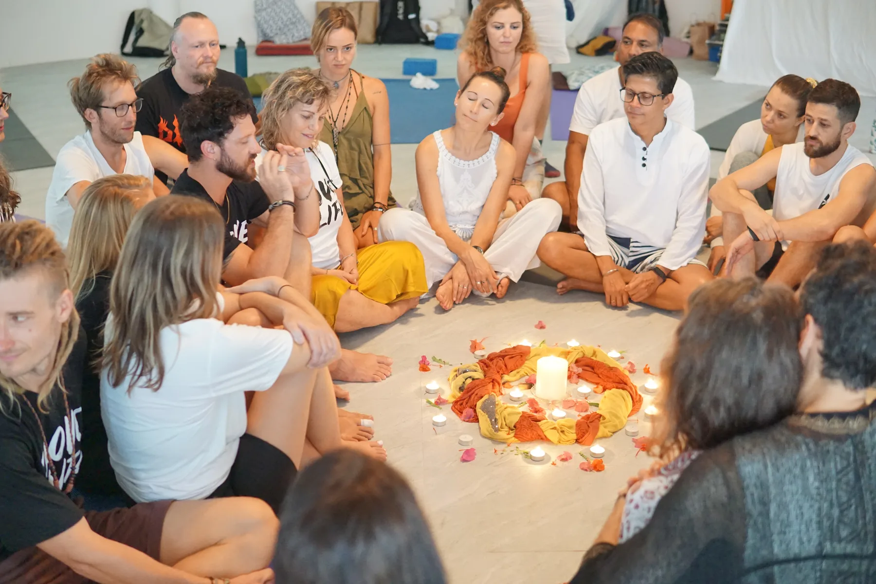 Facilitator-led circle ceremony with candle and flowers